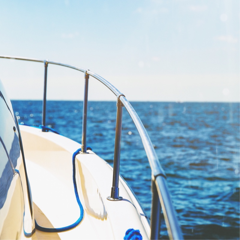 A front right side of a boat and the ocean beyond it