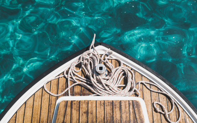 Rope tied up at the end of a boat over turqoise waters